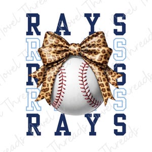 May include: A baseball with red stitching and a leopard print bow. The word "RAYS" is displayed in navy blue and light blue block letters on a white background. The design is a sports-themed graphic.