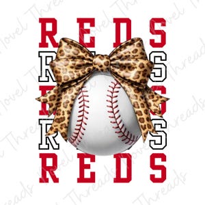 May include: A white baseball with red stitching and a leopard print bow. The word "REDS" is displayed vertically in red and black block letters on a white background. The bow is centered above the baseball.