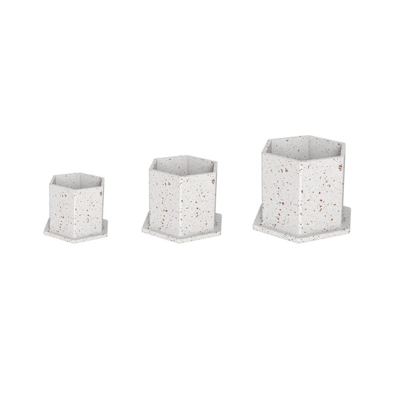 May include: Three white hexagonal ceramic planters with a speckled brown and white pattern. The planters are different sizes, with the largest planter in the back and the smallest planter in the front.