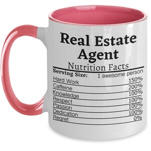 May include: White ceramic coffee mug with a pink rim and handle. The mug features a nutrition facts label with the text "Real Estate Agent" and lists the percentage of hard work, caffeine, knowledge, respect, passion, dedication, and regret.