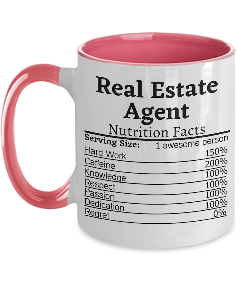 May include: White ceramic coffee mug with a pink rim and handle. The mug features a nutrition facts label with the text "Real Estate Agent" and lists the percentage of hard work, caffeine, knowledge, respect, passion, dedication, and regret.