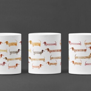 May include: Three white ceramic mugs with a repeating pattern of watercolor dachshunds in various shades of brown, orange, and beige.