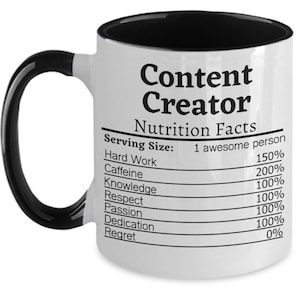 May include: White ceramic mug with a black interior and handle. The mug features the text "Content Creator" above a "Nutrition Facts" label. The label lists ingredients like Hard Work, Caffeine, and Passion.