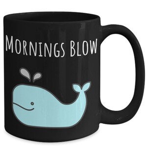 May include: Black coffee mug with a white whale graphic and the text "Mornings Blow".