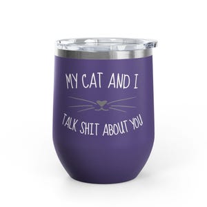 Op de afbeelding: Een paarse ge&iuml;soleerde tumbler met een doorzichtige deksel. De tumbler heeft de tekst "MY CAT AND I TALK SHIT ABOUT YOU" in het wit, samen met een kattengezicht. De tumbler is ontworpen om dranken koud of warm te houden.
