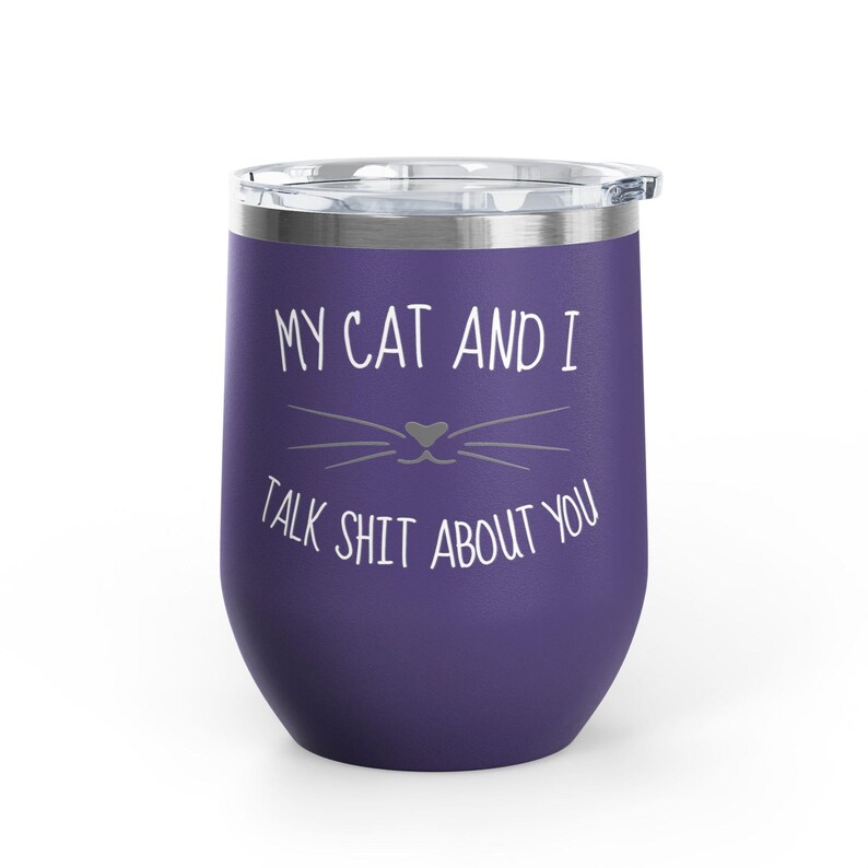 Op de afbeelding: Een paarse ge&iuml;soleerde tumbler met een doorzichtige deksel. De tumbler heeft de tekst "MY CAT AND I TALK SHIT ABOUT YOU" in het wit, samen met een kattengezicht. De tumbler is ontworpen om dranken koud of warm te houden.