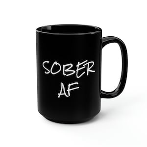May include: Black ceramic mug with white text that reads "SOBER AF".