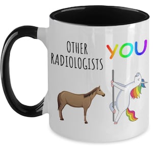May include: White coffee mug with a black rim and handle. The mug has a black horse on the left side and a rainbow unicorn on the right side. The text "Other Radiologists" is on the left side and "You" is on the right side.