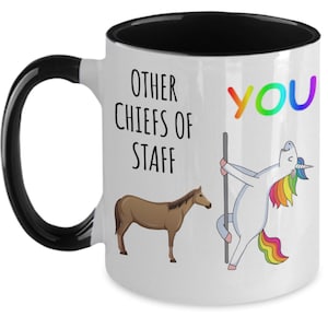 Puede incluir: Taza de cerámica blanca con asa e interior negros. La taza presenta el texto "OTHER CHIEFS OF STAFF" y "YOU" en colores arcoíris, junto con ilustraciones de un caballo y un unicornio.