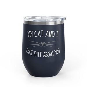 Op de afbeelding: Een marineblauwe ge&iuml;soleerde tumbler met een zilveren rand en deksel. De tumbler heeft witte tekst met de tekst "MY CAT AND I TALK SHIT ABOUT YOU" met een kattengezichtsgrafiek. De tumbler is ontworpen om dranken koud of warm te houden.