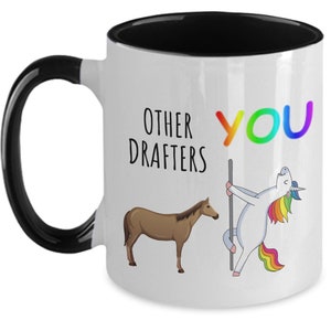 May include: White ceramic coffee mug with a black rim and handle. The mug has a graphic of a unicorn with a rainbow mane and tail, and a horse. The text on the mug reads "Other drafters You".