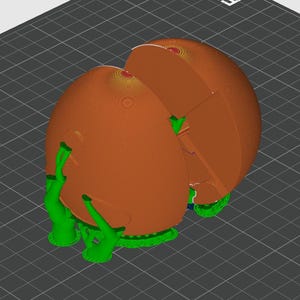 May include: A 3D printed object featuring a large, smooth, orange spherical shell divided into two main sections. The structure is supported by bright green, branching support struts that extend from the base to the exterior of the orange sphere.