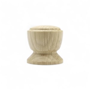 May include: A light-colored, wooden cabinet knob with a rounded top and a flared base. The knob is made of unfinished wood, showcasing the natural grain and texture. The design is simple and classic, suitable for various furniture styles.