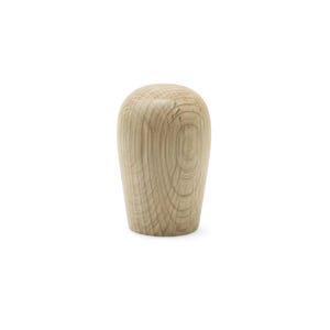 Puede incluir: Un pomo de madera de color claro, con una parte superior redondeada y una base ligeramente cónica. La veta de la madera es visible, mostrando anillos concéntricos. El pomo es probablemente para un armario o un cajón.