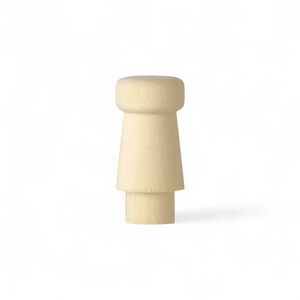Op de afbeelding: Een lichtbeige houten flesstopper. De stopper heeft een cilindrische bovenkant, een conische middensectie en een kleinere cilindrische basis. Het ontwerp is eenvoudig en modern, geschikt voor diverse flessoorten.