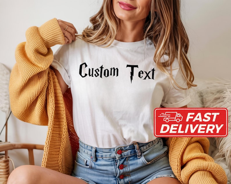 May include: White t-shirt with the text "Custom Text" in a black, stylized font. A red rectangle with the words "Fast Delivery" is in the lower right corner. The person is wearing a yellow cardigan and blue denim shorts.