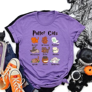May include: Purple t-shirt with a black and white graphic of cats with names inspired by Harry Potter characters. The text "Potter Cats" is at the top of the graphic.
