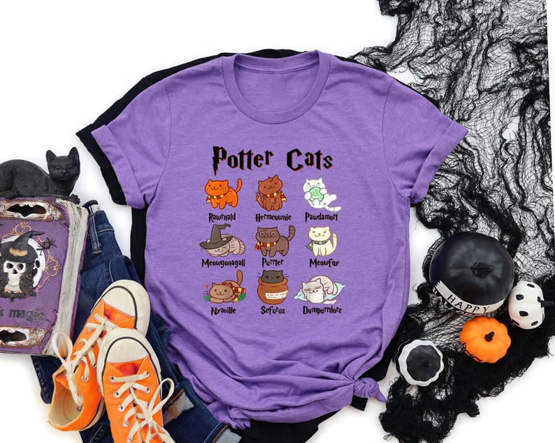 May include: Purple t-shirt with a black and white graphic of cats with names inspired by Harry Potter characters. The text "Potter Cats" is at the top of the graphic.