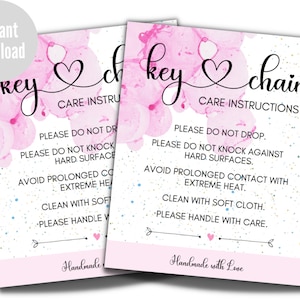 May include: Two pink and white watercolor cards with the text "key chain" and "key" with a heart symbol. The cards have care instructions for the keychain, including "Please do not drop", "Please do not knock against hard surfaces", "Avoid prolonged contact with extreme heat", "Clean with soft cloth", and "Please handle with care". The cards also say "Handmade with Love".