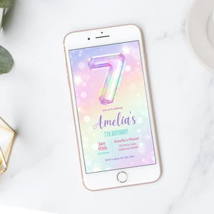 May include: A digital invitation for a 7th birthday party. The invitation features a rainbow iridescent number 7 with a glittery background. The text reads "Join us to celebrate Amelia's 7th Birthday!" with the date and time of the party, the location, and RSVP information.
