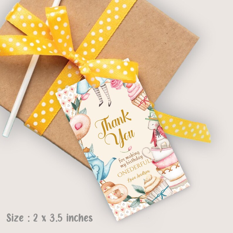 May include: A white thank you tag featuring a watercolour illustration of Alice in Wonderland characters and tea party elements. The text reads "Thank You for making my birthday ONEDERFUL Love Andrea".