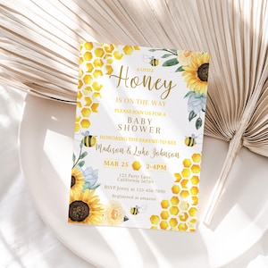 May include: A baby shower invitation with a yellow and white honeycomb pattern, sunflowers, and bees. The text reads "A Little Honey Is On The Way. Please Join Us For A Baby Shower Honoring The Parent-To-Bee Madison & Luke Johnson. Mar 25 2-4PM. 123 Party Lane, California 56789. RSVP Jenny at 123-456-7890. Registered at amazon."