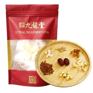 May include: A red and gold bag with the text "九龍堂 ROYAL SEAFOOD USA" on it. The bag contains a white, dried product. A wooden plate with various dried ingredients, including red dates, lotus seeds, and ginseng, is shown in the foreground.