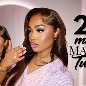 May include: A woman with long, wavy brown hair and full makeup is featured in a beauty tutorial. The text "20 minute MAKE UP Tutorial" is displayed in black script. She wears a pink striped shirt and jewelry.