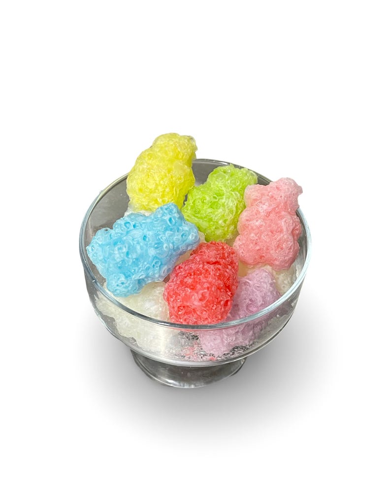 May include: A glass bowl filled with colorful gummy bear shaped candies. The candies are in shades of blue, green, yellow, pink, and purple.