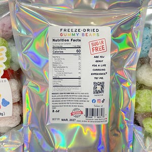 May include: A bag of freeze-dried gummy bears with a holographic iridescent finish. The bag is labeled "Freeze-Dried Gummy Bears" and "Sugar Free". The nutrition facts are listed on the back of the bag. The bag is 2 oz (60g).