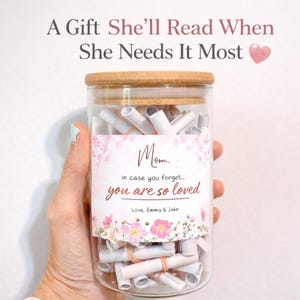 May include: A clear glass jar with a bamboo lid filled with rolled-up notes. The jar has a label that reads "Mom, in case you forget... you are so loved." The text "A Gift She'll Read When She Needs It Most" is at the top.