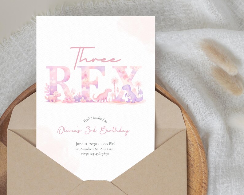 May include: A light pink birthday invitation card with the text "Three REX" in a playful font, featuring dinosaur illustrations. The card is inside a brown envelope, with additional text inviting guests to Olivia's 3rd birthday.