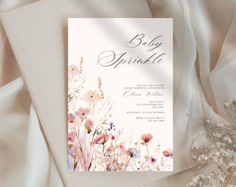 May include: Baby Sprinkle invitation with floral watercolor design. The invitation features the text "Baby Sprinkle" in elegant script, along with event details. Soft pink, purple, and brown flowers adorn the bottom left corner.