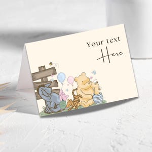 Könnte beinhalten: Eine gefaltete cremefarbene Karte mit dem Text "Your text Here". Die Karte zeigt Illustrationen von Winnie-Puuh-Charakteren, darunter Puuh, Ferkel, I-Aah und Tiger, mit Luftballons und einem Holzzaun. Eine Biene und Schmetterlinge sind ebenfalls vorhanden.
