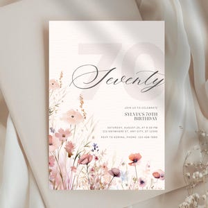 May include: A 70th birthday invitation featuring the word "Seventy" in a stylish script. The invitation includes details for Sylvia's 70th birthday, with a floral design in soft pinks and purples.