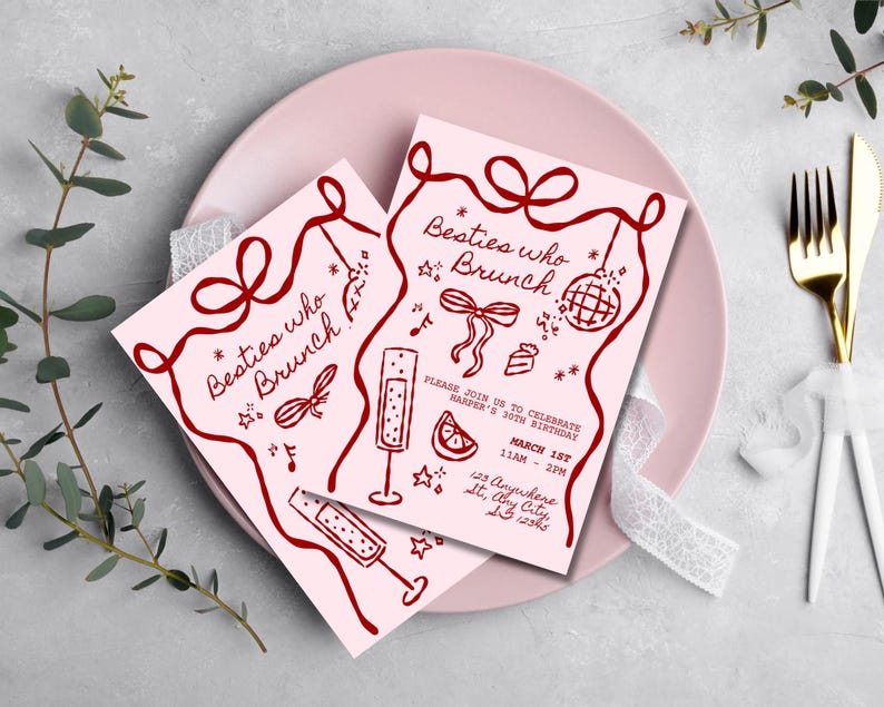 May include: Two pink invitation cards with burgundy text and illustrations, reading "Besties who Brunch." The cards feature a bow, disco ball, champagne flutes, and a slice of citrus. The invitations are on a pink plate with gold cutlery.