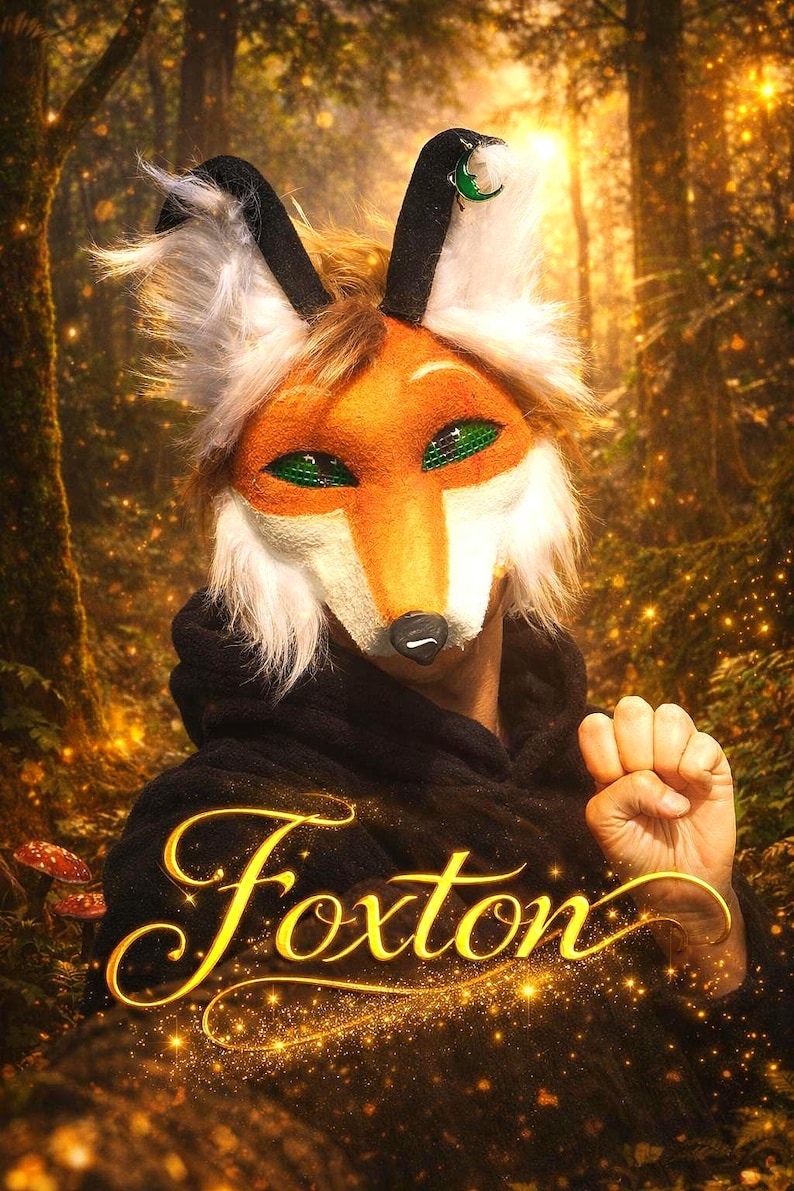May include: A vibrant orange and white fox mask with green eyes and black accents. The mask has a furry texture and is worn with a black hooded garment. The word "Foxton" is written in gold script.