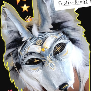 Hi there! Frolic-King is a majestic spirited therian mask full of pride. Frolic-King is a coyote theriotype. You could customize his style to another theriotype, such as a fox. this mask is a monochromatic white and black mask. The Mask has white highlights that descend all the way to the Dark Shadows of black his eyes are black and the pupils are gold stars gold accents are overlaid on his beautiful face in pattern such as a dragonfly on his nose a swirl on his forehead. order today.