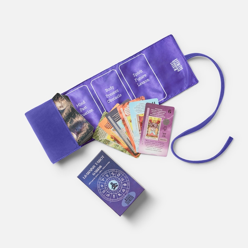 May include: A purple tarot card set with a matching carrying case. The case is open, revealing a deck of cards and a small box labelled "Learning Tarot Cards". The case has sections labelled "Mind Past Situation", "Body Present Obstacle", and "Spirit Future Lesson".