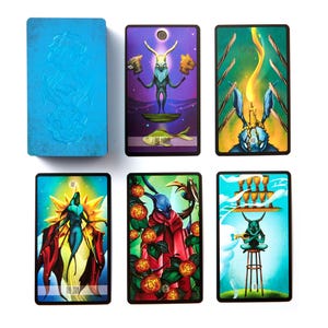 May include: A tarot card deck featuring vibrant illustrations. The deck includes cards with images of a rabbit-like figure, a fish, and other symbolic imagery. The card backs are blue with a textured design.
