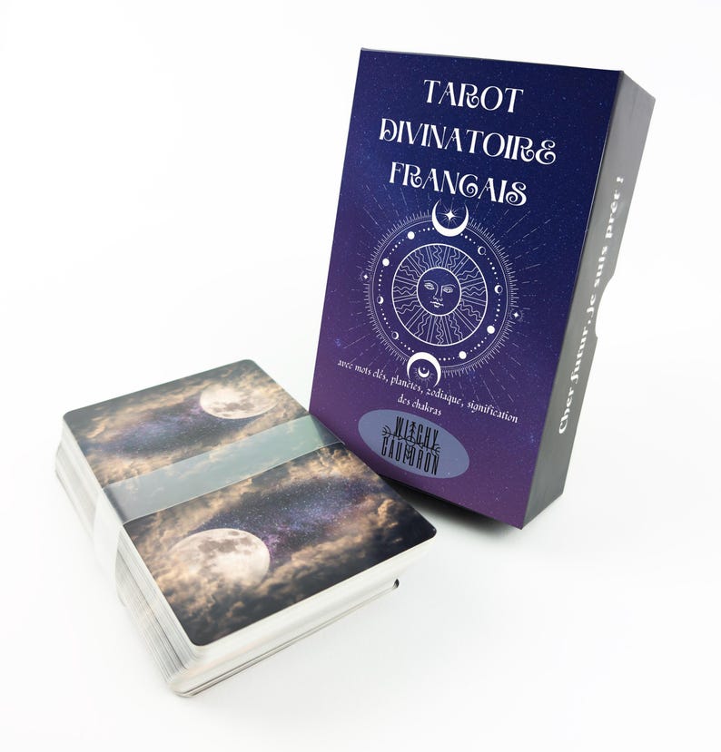 May include: A deck of tarot cards with a box. The box is dark blue and purple with the words "TAROT DIVINATOIRE FRAN&Ccedil;AIS" in white. The box has a sun and moon design. The deck of cards has a space-themed design.