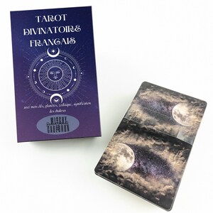 May include: A tarot card deck and box set. The box is dark purple with white text that reads "TAROT DIVINATOIRE FRANGAIS". The box has a celestial design with a sun, moon, and stars. The cards have a night sky and moon design.