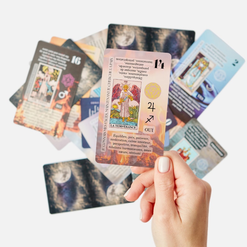 May include: A collection of tarot cards, with one card held in a hand. The featured card, labeled "LA TEMPERANCE," displays an angel illustration and French text. Other cards show various images and numbers, including "16" and "14."