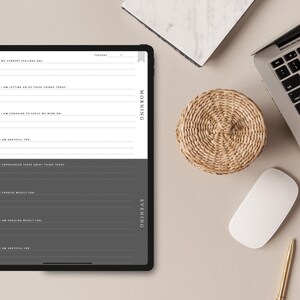 May include: A digital planner on a tablet screen with a gray background. The planner is divided into two sections: Morning and Evening. Each section has prompts for reflection and gratitude. The text on the screen reads "My current feelings are", "I am letting go of these things today", "I am choosing to focus my mind on", "I am grateful for", "I experienced these great things today", "Forgiving myself for", "I am praising myself for", "I am grateful for".