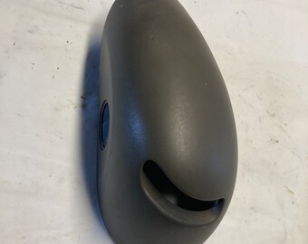 Könnte beinhalten: Ein graues Kunststoff-Autoteil mit abgerundeter Form und einer kleinen Lüftung an der Seite.