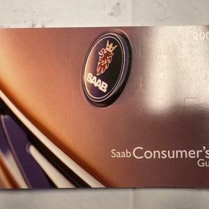 May include: A brown and gold Saab car consumer's guide booklet with the Saab logo and the year 2004 printed on the cover.
