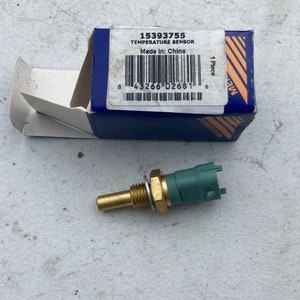 Peut inclure: Un capteur de température vert et or avec le numéro de pièce 15393755 et le texte "Temperature Sensor" et "Made in: China" sur l'emballage.