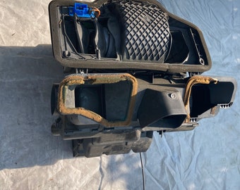 May include: A black plastic air intake system with a black foam filter and a blue connector. The system is rectangular in shape and is made up of multiple parts.