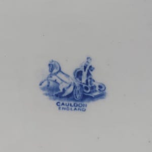 May include: A blue and white illustration of a horse-drawn chariot with a driver. The text "CAULDON ENGLAND" is below the illustration. The image is on a white background.
