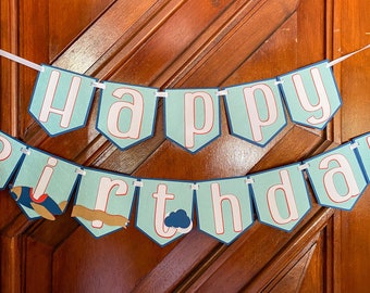 May include: A blue and white banner with the words "Happy Birthday" in white letters with red outlines. The banner has a blue and white airplane and a blue cloud on it.